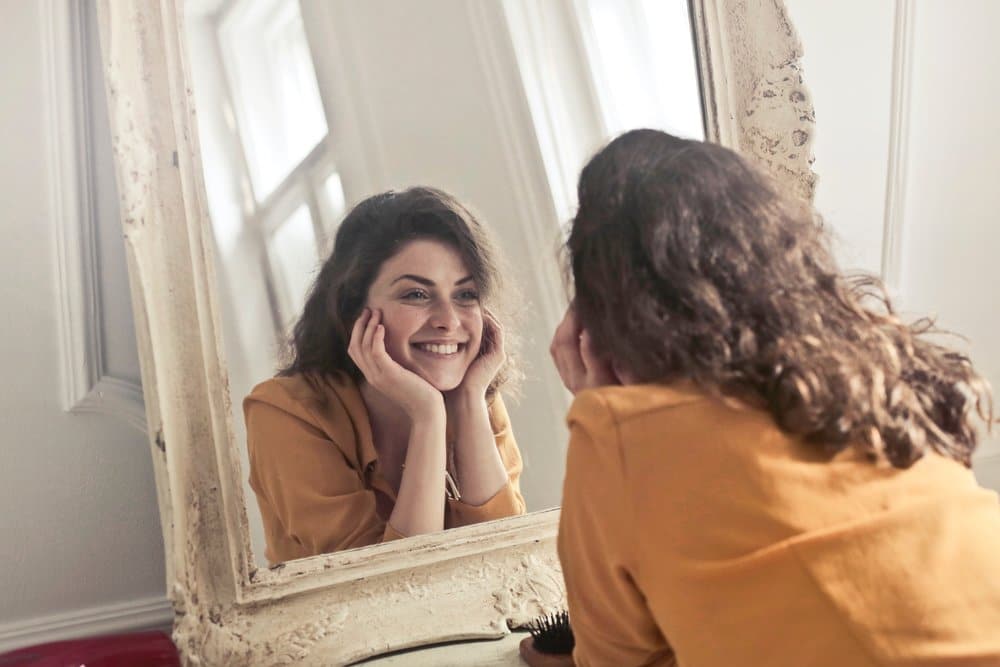 smiling woman looking at her reflection